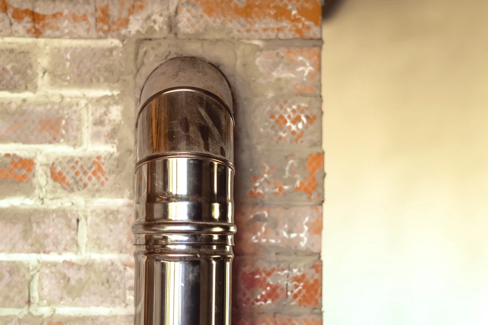 Intérieur avec mur de briques apparentes et conduit de cheminée en inox