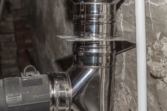 Intérieur d'une cave ou sous-sol avec installation de conduit de cheminée