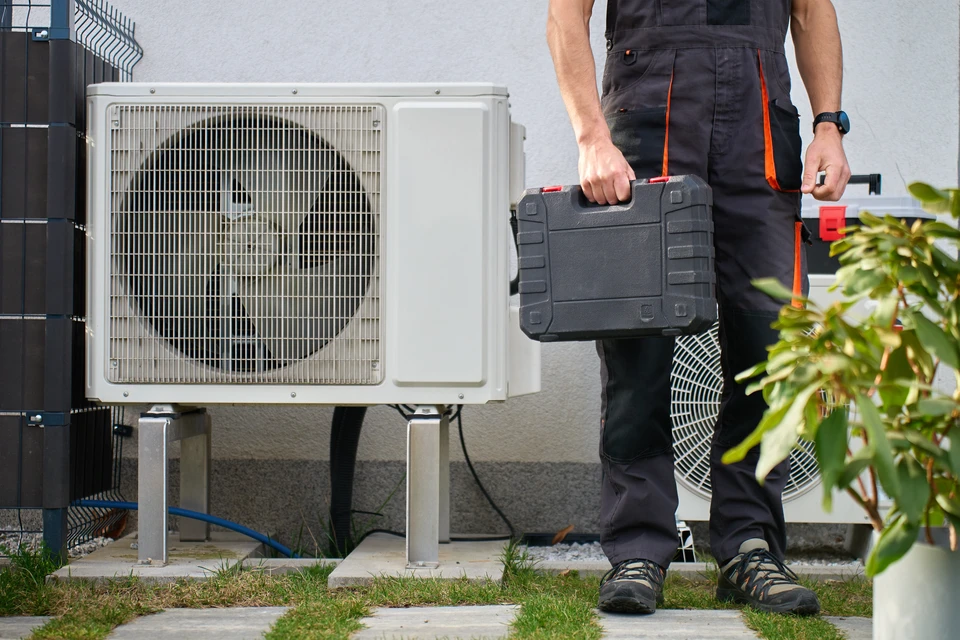 Extérieur résidentiel moderne avec pompe à chaleur air-eau installée sur terrasse béton