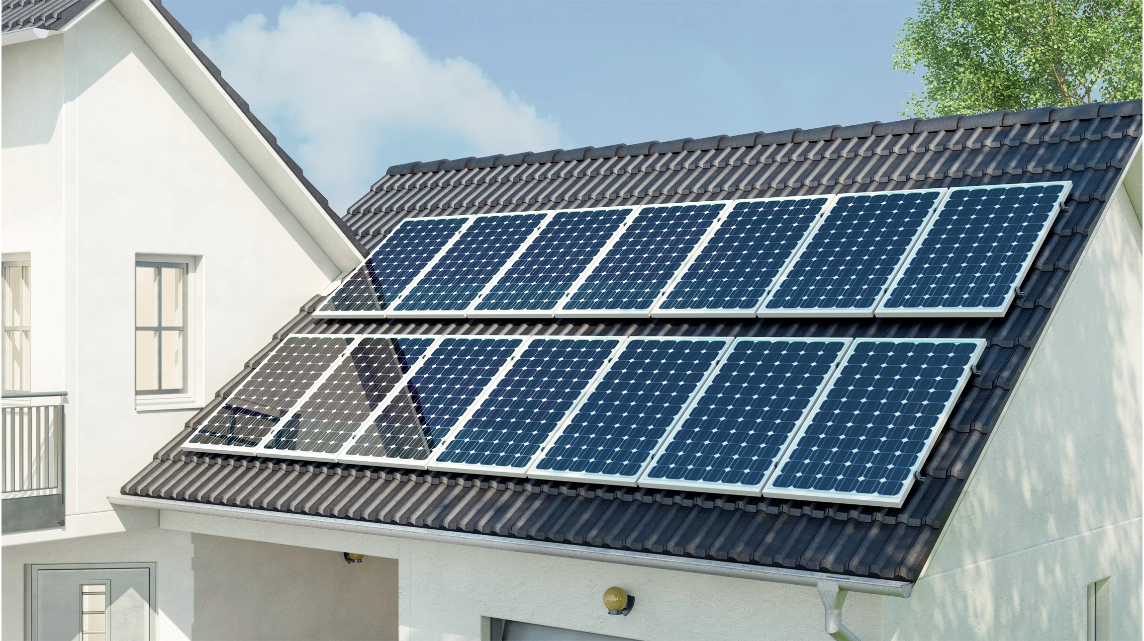 Deux techniciens en tenues de travail rouges installent des panneaux photovoltaïques sur une toiture en tuiles par temps ensoleillé