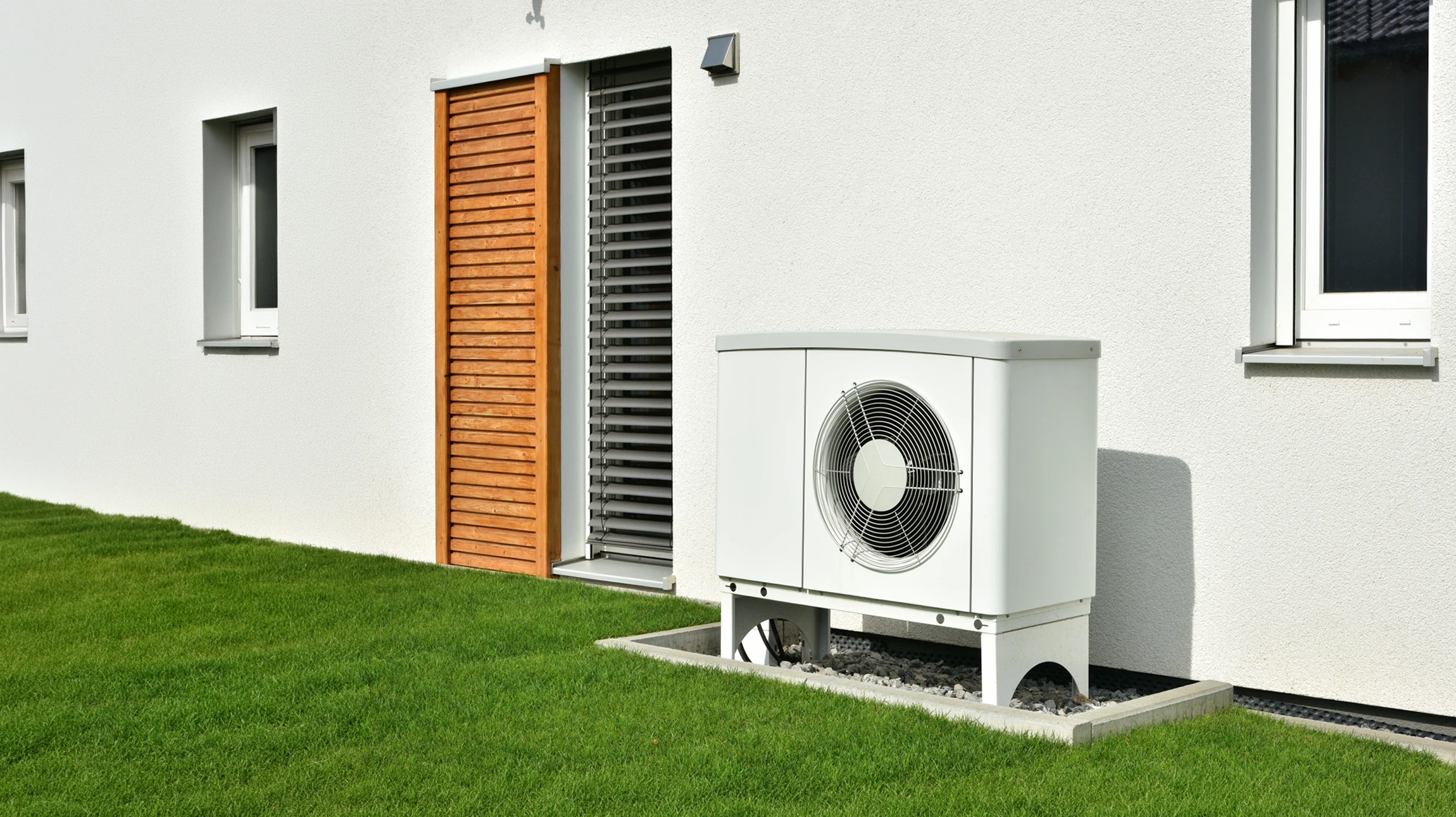 Extérieur d'un bâtiment résidentiel avec unité de climatisation installée sur mur en briques beiges